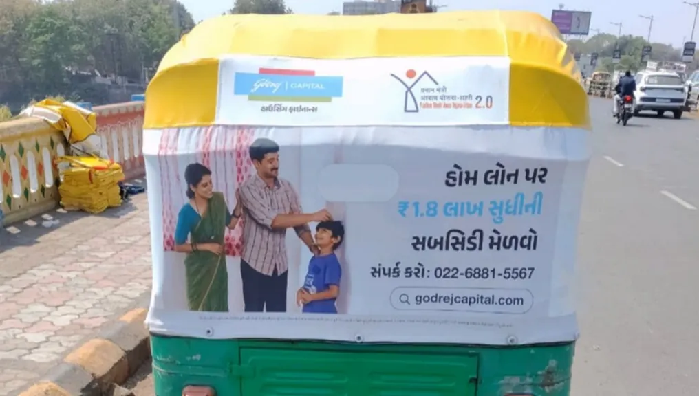 Godrej Capital auto-rickshaw hood branding in Gujarati carrying the PMAY-U 2.0 home loan subsidy offer