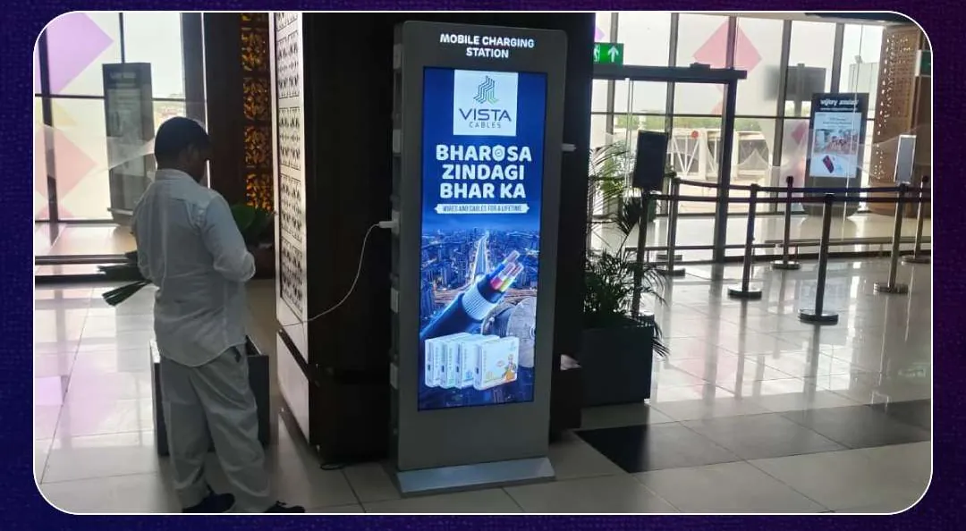 A visitor charging a phone at the Vista Cables kiosk