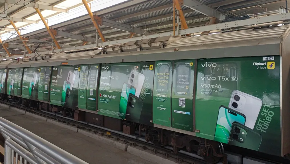 Vivo T5x train branding read from the platform as the train stands at the station